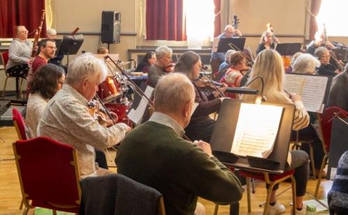 Orchestra players in sunny hall