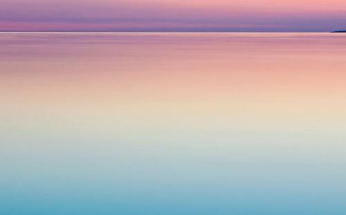 Calm ocean against a purple/pink sunset