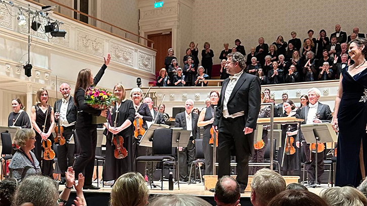 music director and performers stand on stage after the concert