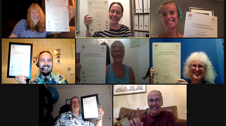 screenshot of people holding their certificates to the screen over Zoom