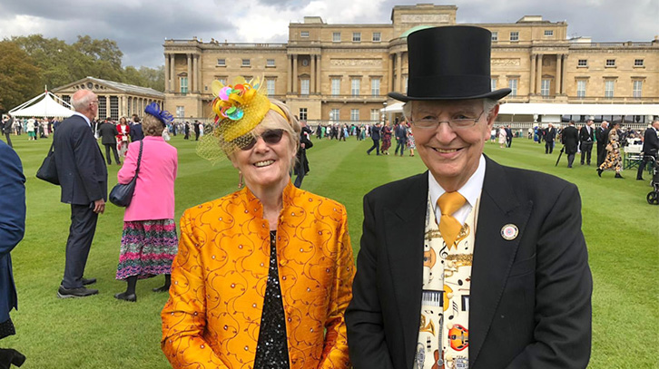 Peter and Vivien pose in front of the Buckingham Palace