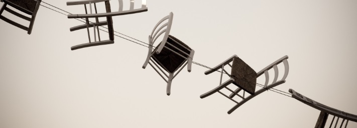 A row of chairs suspended from some wires in mid air