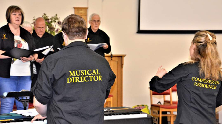 the musical director and composer directing the choir