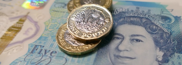 three £1 coins on top of a £5 note