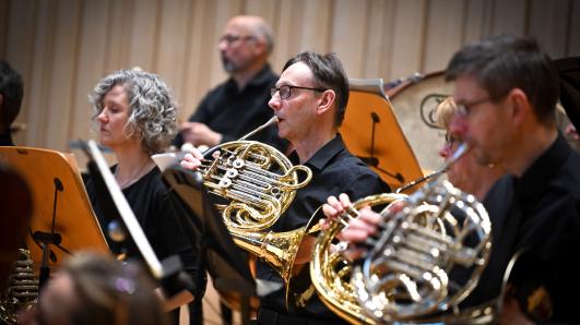 Members of the Glasgow Orchestra Society playing a French horn