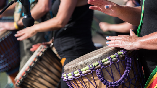 african drummers beating drums in front of microphone