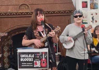 people singing and playing ukuleles in a library