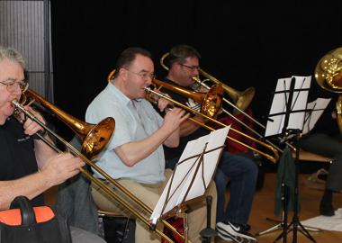 three people playing trombones