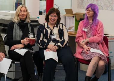 Four musicians sitting in chairs and smiling at the making music adopt a music creator launch