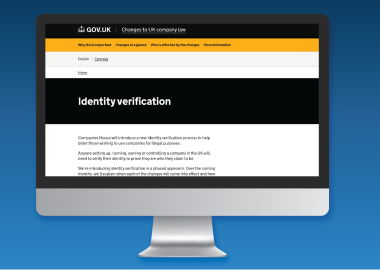 Computer monitor displaying a GOV.UK webpage about identity verification changes by Companies House, explaining new requirements for company directors in the UK.