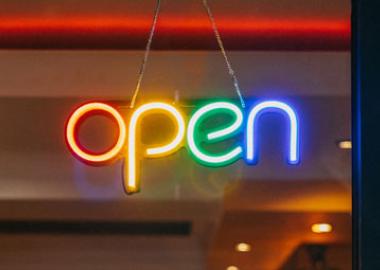 Multi coloured neon 'open' sign in a door window