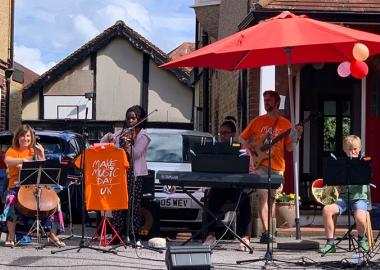 Five members of The Penton Road Band performing in a driveway in Staines, Surrey, as part of Make Music Day 2020