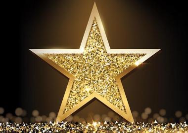 Gold star shining in front of a dark background