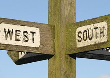 A wooden signpost with arms pointing north, south, east and west
