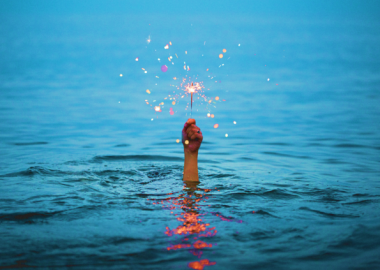 sparkler hand emerging from the sea