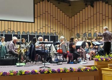 musicians on stage, sitting down and playing their instruments