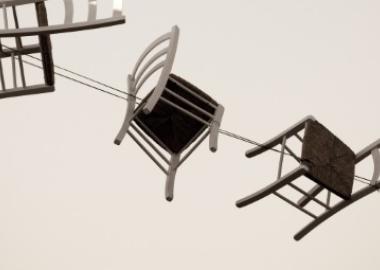Brown wooden chairs flying through the air