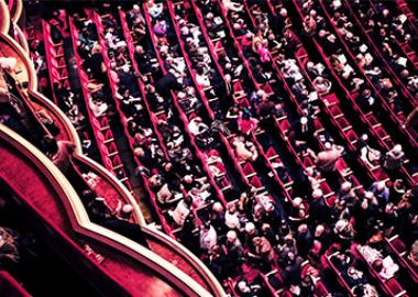 red concert hall full with patrons
