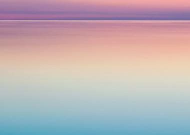 Calm ocean against a purple/pink sunset