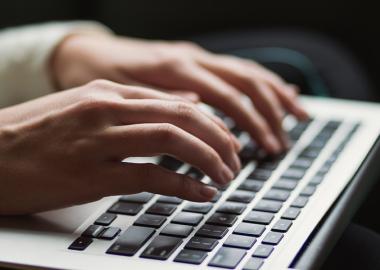 An individual's hands typing on a laptop