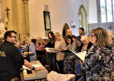 members of choir standing up in a church and singing