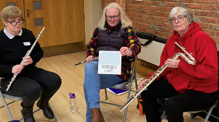 three members of the flute ensemble sitting down
